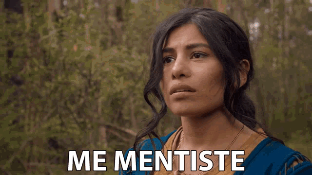 a woman in a blue shirt says me mentiste in front of trees