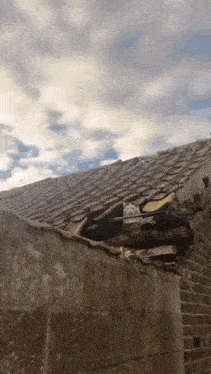 a roof with a hole in it and a cloudy sky