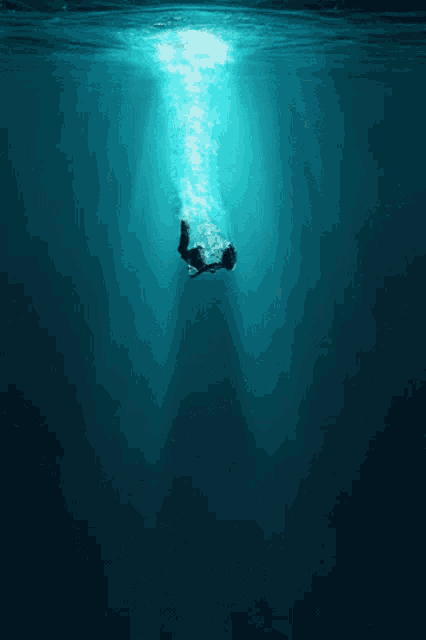 a person is swimming in the ocean with the sun shining through