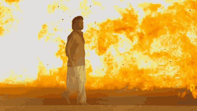 a man is standing in front of a large fireball