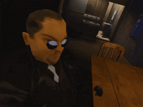a man wearing sunglasses is holding something in his mouth in a dark room