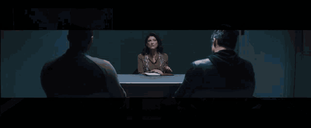 two men sit at a table in a dark room with the words who would like to start above them