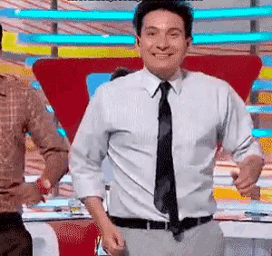 a man in a white shirt and black tie is dancing on a stage .