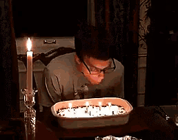 a man is blowing out a candle on a birthday cake with the words alles gute zum geburtstag written on the bottom
