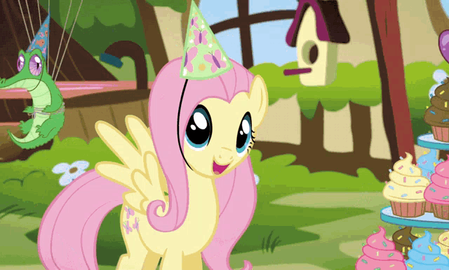 a cartoon pony wearing a party hat is standing in front of cupcakes