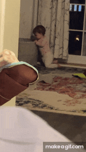 a baby is crawling in a room with a make a gif.com button
