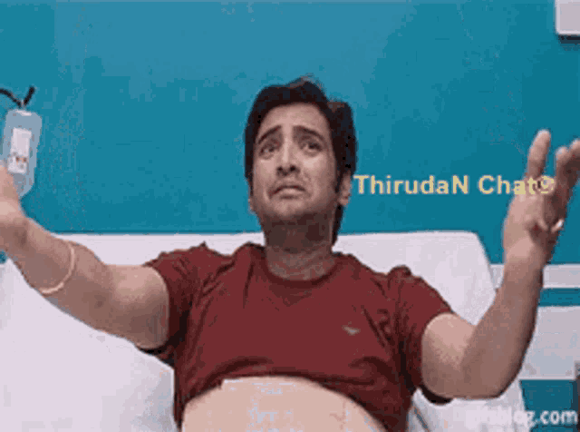 a man in a red shirt is laying in a hospital bed