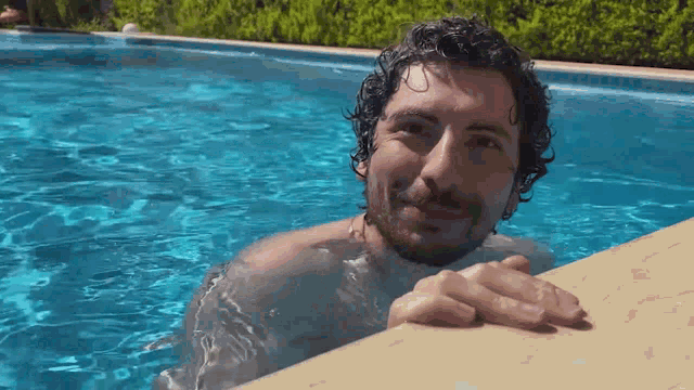 a man with a beard is swimming in a pool