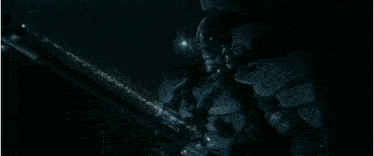 a man in a space suit is standing on a rocky planet .