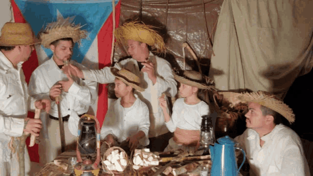 a group of people are gathered around a table with a flag in the background