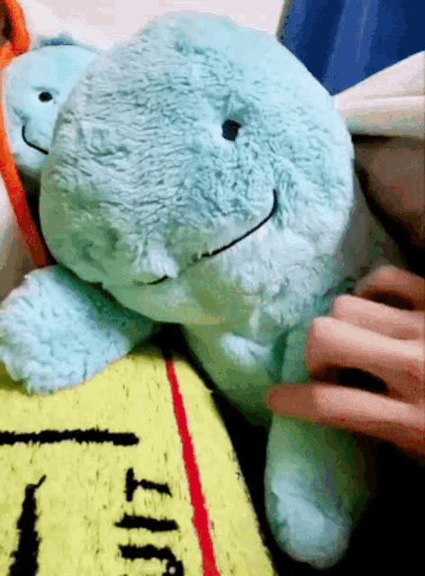 a person is petting a stuffed animal on a blanket that says t.t.t.