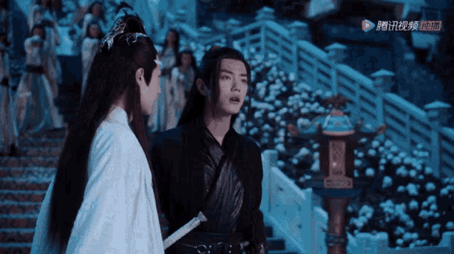 a man holding a sword stands next to a woman in a white dress with chinese writing on the bottom