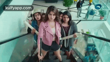 a group of women are standing on a set of stairs in a building .