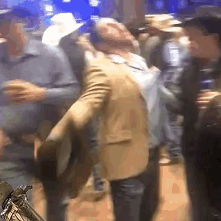 a man in a suit is dancing in a crowd