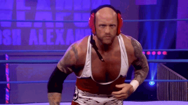 a man in a wrestling ring with the words alexa on the wall behind him