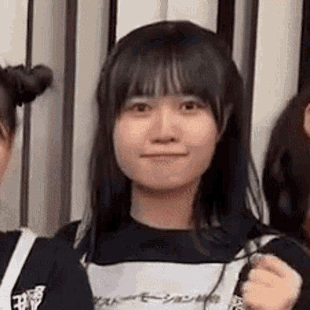 a close up of a young woman 's face while standing next to another young woman .