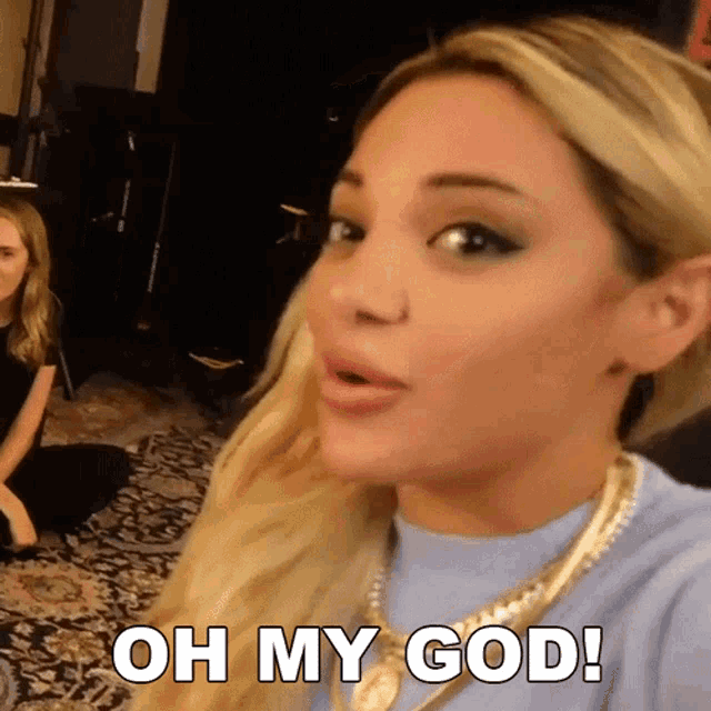 a woman with blonde hair and a gold necklace says " oh my god "