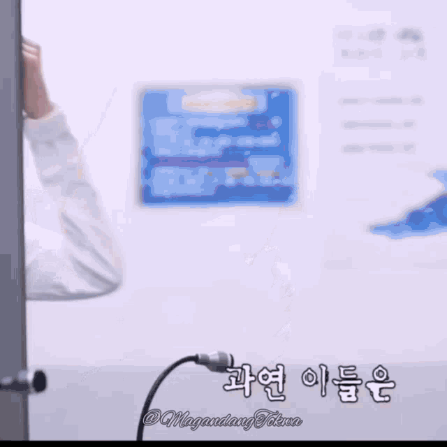 a woman in a white shirt is standing in front of a microphone in front of a wall with chinese writing on it