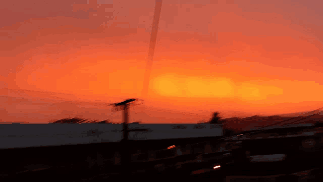 a blurry picture of a sunset with a building in the foreground that says ' abercrombie & fitch ' on it