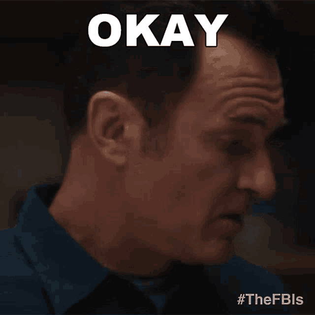 a man in a blue shirt says okay in white letters