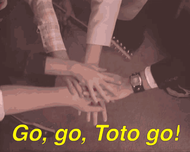 a man with glasses is writing in a notebook with the words go go toto go behind him