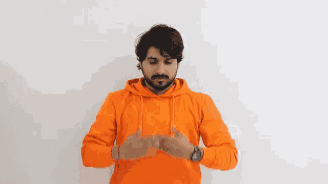a man with a beard wearing a bright orange hoodie