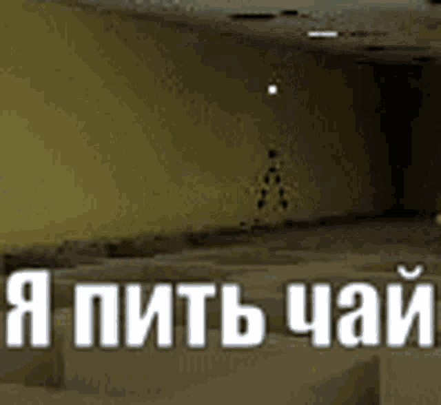 a person is standing in an empty room with the words `` i 'm drinking tea '' written in russian .