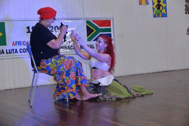 two women dancing in front of a sign that says africa on it