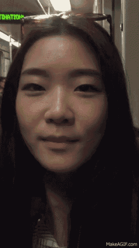 a close up of a woman 's face in front of a sign that says " donations "