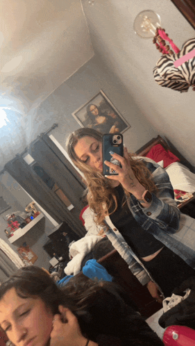 a woman taking a picture of herself in front of a mirror