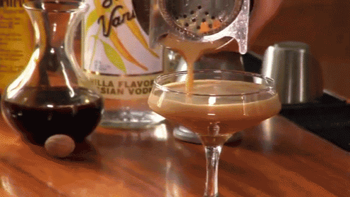 a bottle of vanilla flavored asian vodka is poured into a glass