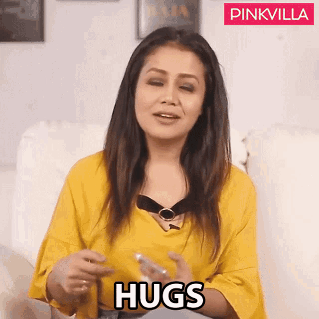 a woman in a yellow shirt is giving a hug