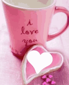 a pink coffee cup that says i love you next to a heart shaped cookie