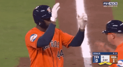 a baseball player with the number 44 on his jersey is high fiving another player