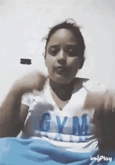 a woman is wearing a white shirt with the word gym on it .