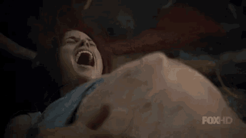 a woman is crying while holding a man 's belly .