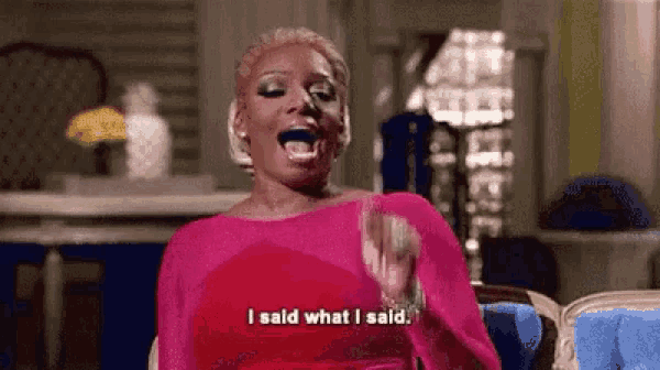 a woman in a pink dress is sitting in a chair and screaming .