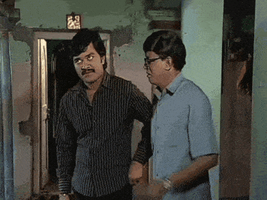 two men standing next to each other in front of a door with a sign that says ' a ' on it