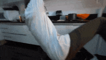 a person is doing a leg lift in a kitchen
