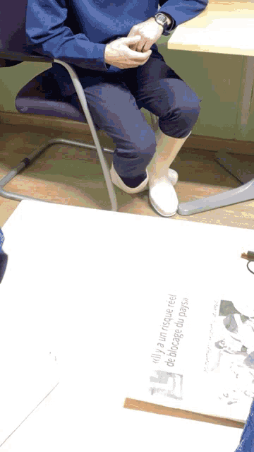 a person wearing white boots sits on a chair next to a sign that says " only a few people need to know "