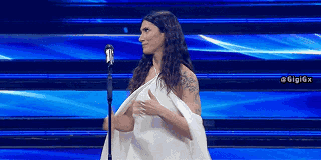 a woman is standing in front of a microphone on a stage .