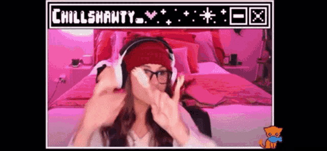 a woman wearing headphones and a red hat is giving the peace sign
