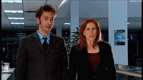 a man and a woman are standing next to each other in a hallway .