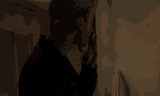 a man is lighting a cigarette with a lighter in a dark room