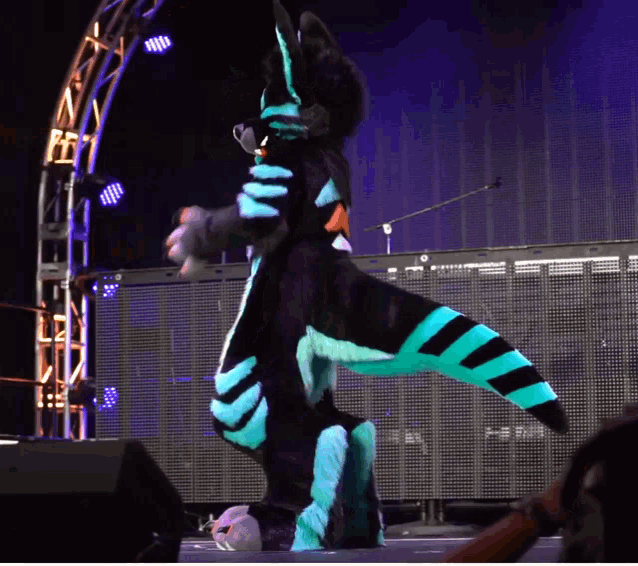 a person in a furry costume stands on a stage
