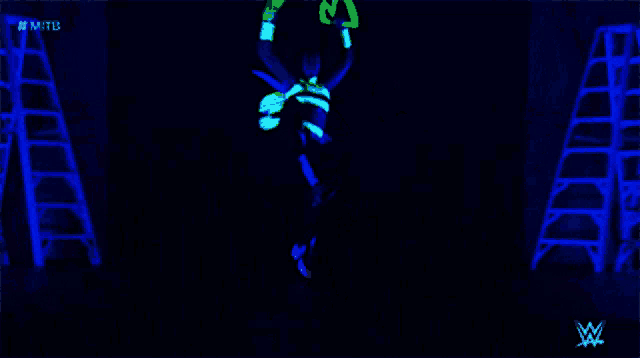 a man is glowing in the dark in front of a stack of ladders and a w logo