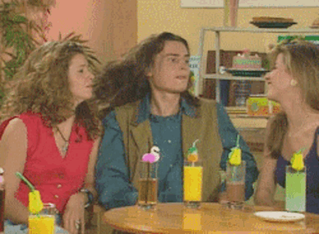 a group of people sitting at a table with drinks on it
