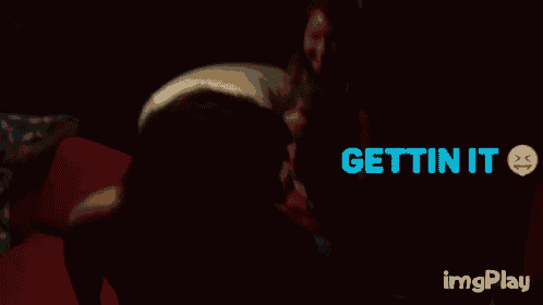 a group of people are sitting in a dark room with the words gettin it written in blue