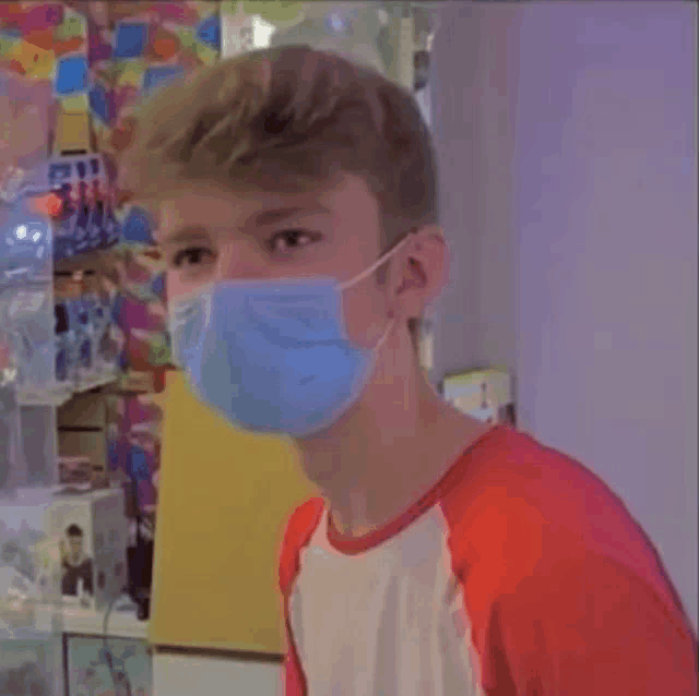 a young man wearing a blue face mask in a store .
