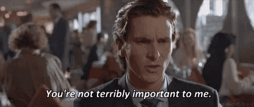 a man in a suit and tie is talking to another man in a crowded restaurant .